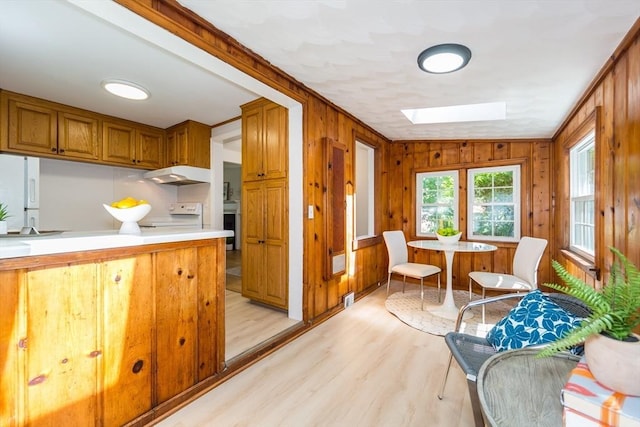 6 Macarthur Rd, Natick, MA 01760 - kitchen featuring under cabinet range hood, a skylight, light wood finished floors, light countertops, and brown cabinetry
