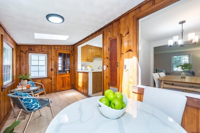 6 Macarthur Rd, Natick, MA 01760 - dining space with a chandelier, wooden walls, light wood-style flooring, and a skylight