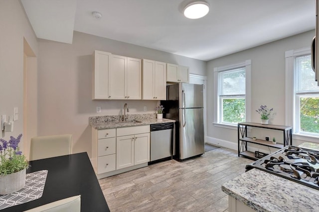 24-26 Bentley St, Boston, MA 02135 - kitchen featuring stainless steel appliances, white cabinetry, light wood-style flooring, and light stone countertops