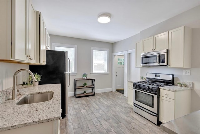24-26 Bentley St, Boston, MA 02135 - kitchen with stainless steel appliances, light wood-type flooring, and light stone countertops