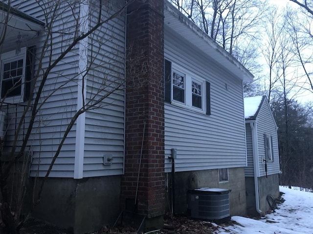 view of snow covered exterior featuring central AC