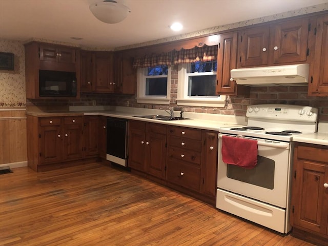 kitchen featuring black appliances, sink, and hardwood / wood-style floors