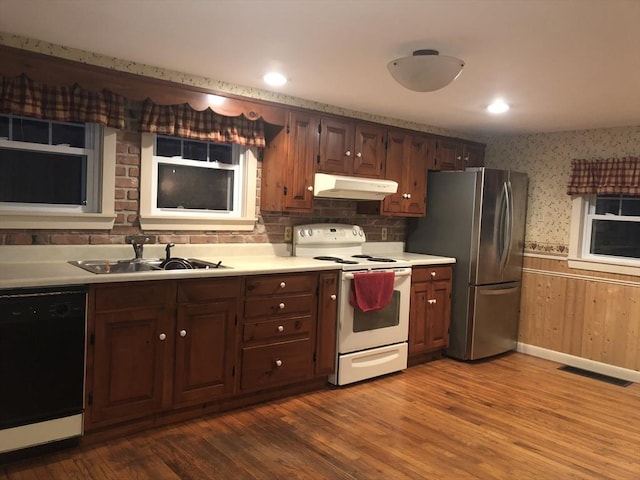 kitchen featuring stainless steel fridge, white range with electric stovetop, sink, hardwood / wood-style flooring, and dishwasher