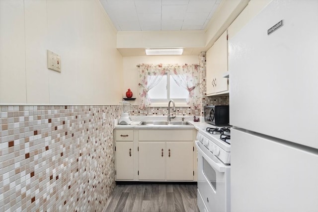376 N Underwood St, Fall River, MA 02720 - kitchen with white appliances, wood finished floors, light countertops, white cabinets, and backsplash