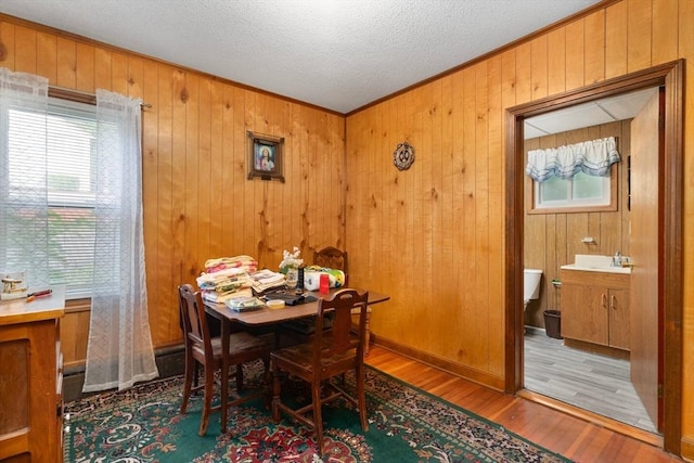 376 N Underwood St, Fall River, MA 02720 - dining room with wood finished floors, healthy amount of natural light, wooden walls, ornamental molding, and a textured ceiling