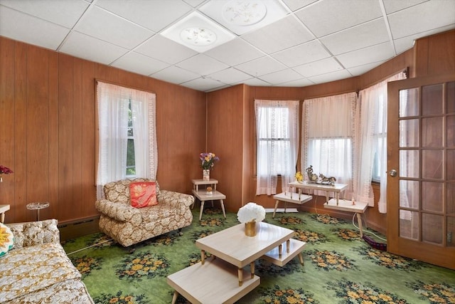 376 N Underwood St, Fall River, MA 02720 - carpeted living room with a baseboard heating unit, wood walls, and a paneled ceiling