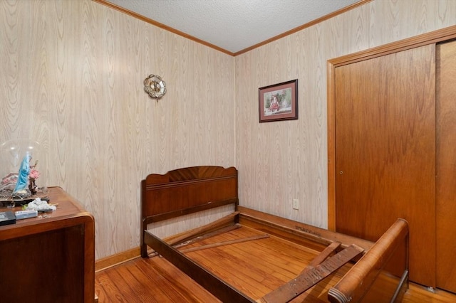 376 N Underwood St, Fall River, MA 02720 - bedroom with ornamental molding, wood finished floors, a textured ceiling, and wooden walls
