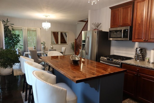 17 Lockwood Ave, Attleboro, MA 02703 - kitchen with stainless steel appliances, a chandelier, wooden counters, a kitchen breakfast bar, and pendant lighting