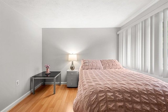 bedroom featuring wood finished floors and baseboards