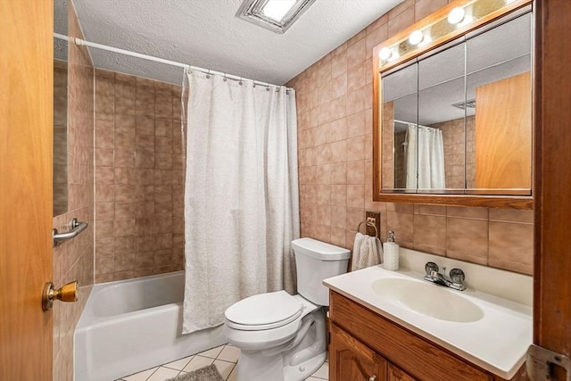 full bath with tile walls, tile patterned floors, a textured ceiling, toilet, and shower / bath combo