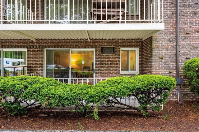 entrance to property with a balcony and brick siding