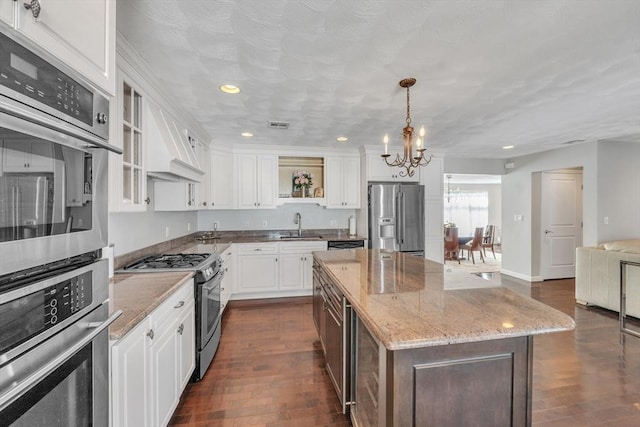 14 Pleasant View Ave, Lynn, MA 01902 - kitchen with stainless steel appliances, a chandelier, dark wood-style flooring, white cabinetry, and a kitchen island