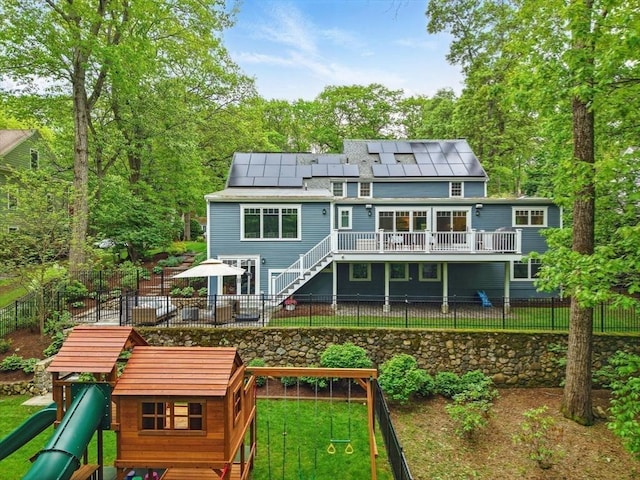 12 Olde Lyme Rd, Winchester, MA 01890 - rear view of house with a playground, solar panels, stairs, a deck, and a patio area