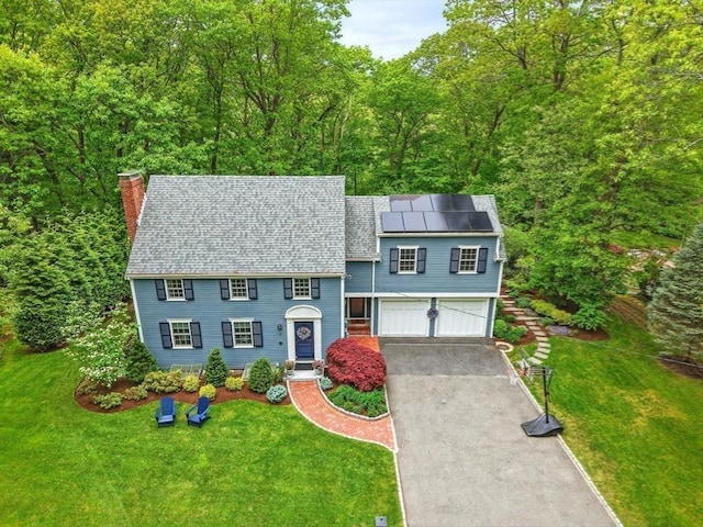 12 Olde Lyme Rd, Winchester, MA 01890 - view of front of property featuring driveway, a chimney, an attached garage, and a front yard