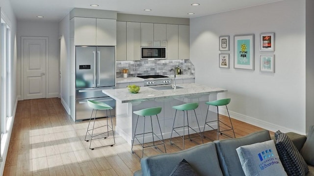 16 Boardman St Unit 204A, Boston, MA 02128 - kitchen featuring high quality fridge, a kitchen breakfast bar, baseboards, tasteful backsplash, and light wood-style floors