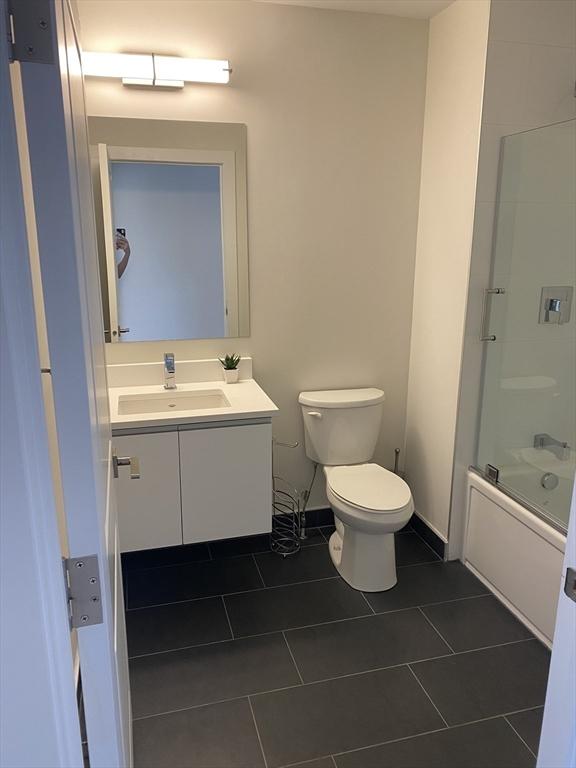 16 Boardman St Unit 204A, Boston, MA 02128 - bathroom with toilet, vanity, tile patterned flooring, and combined bath / shower with glass door