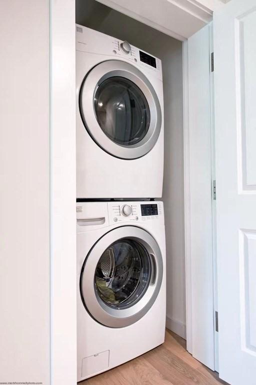 16 Boardman St Unit 204A, Boston, MA 02128 - clothes washing area with stacked washer and clothes dryer and light wood-style floors