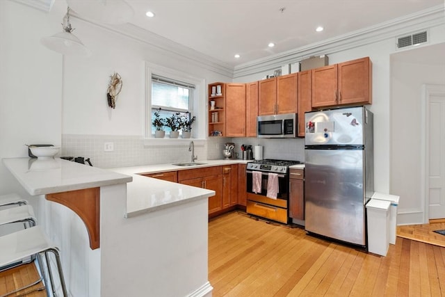 31 Massachusetts Ave Unit 4-4, Boston, MA 02115 - kitchen featuring appliances with stainless steel finishes, a sink, a peninsula, decorative backsplash, and crown molding