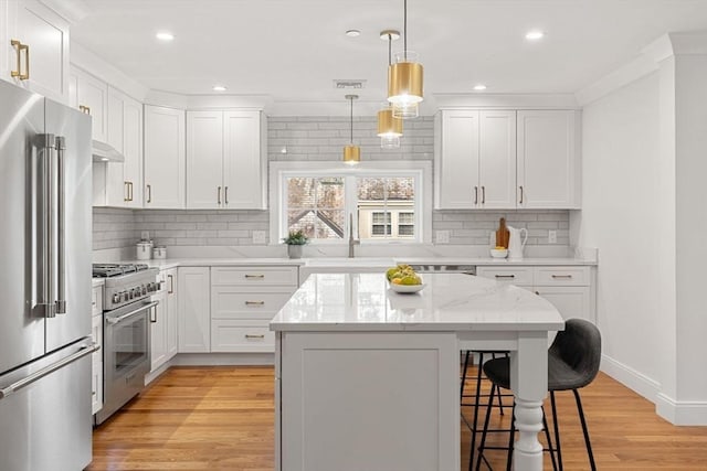 kitchen featuring sink, white cabinetry, a kitchen island, and high quality appliances