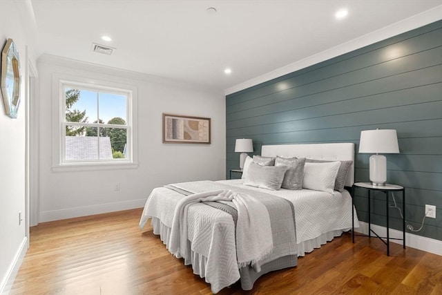 bedroom featuring light hardwood / wood-style flooring and crown molding