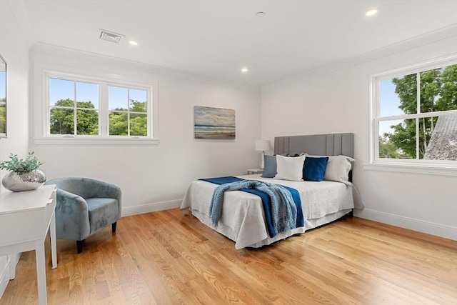 bedroom with light hardwood / wood-style flooring and ornamental molding