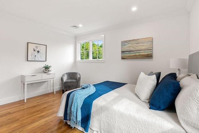 bedroom featuring wood-type flooring and crown molding