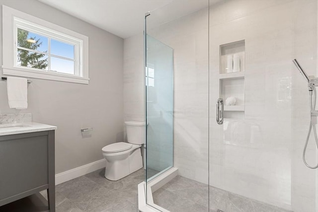 bathroom featuring toilet, an enclosed shower, and vanity