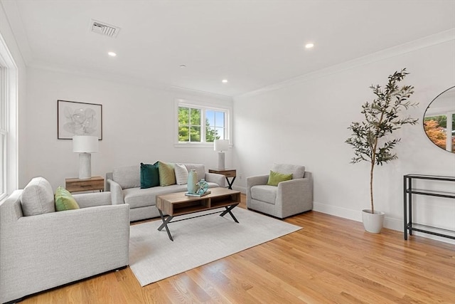 living room with ornamental molding and light hardwood / wood-style flooring