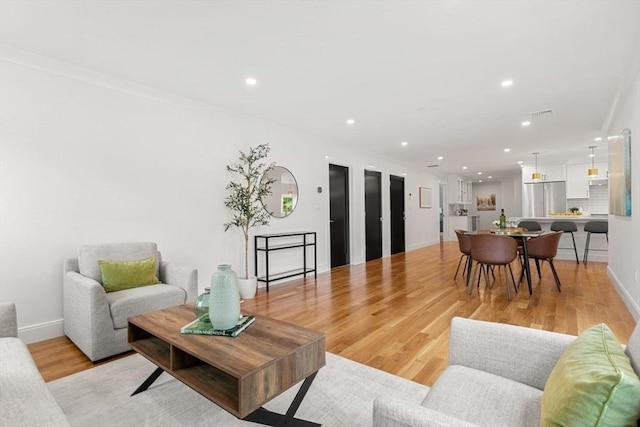 living room featuring light hardwood / wood-style floors and ornamental molding