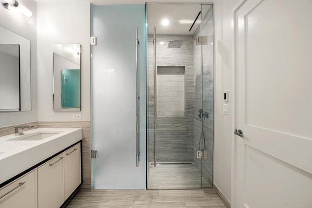 bathroom featuring vanity and a shower with shower door