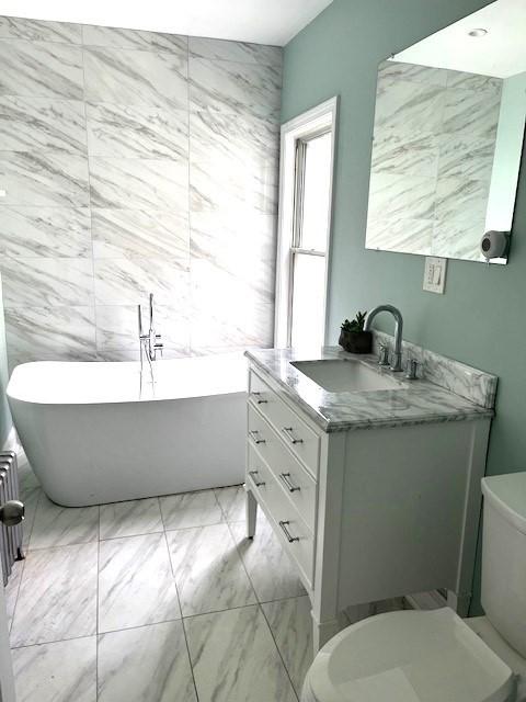 129 3rd St, Lowell, MA 01850 - bathroom featuring vanity, a freestanding bath, marble finish flooring, and toilet