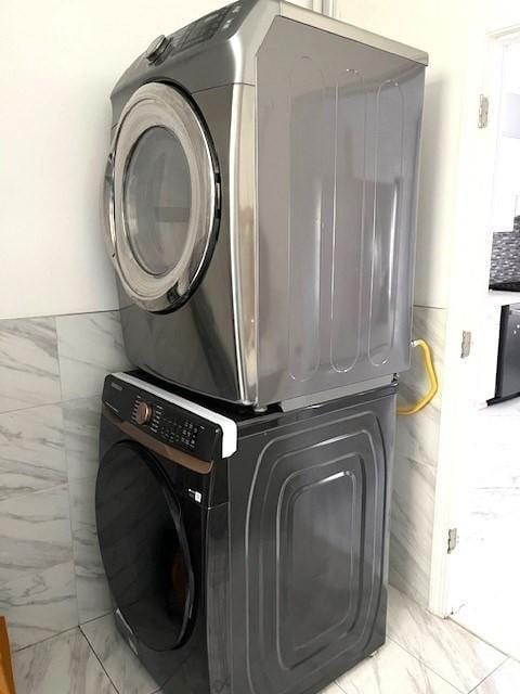 129 3rd St, Lowell, MA 01850 - laundry area with estacked washer and dryer and light marble finish floors