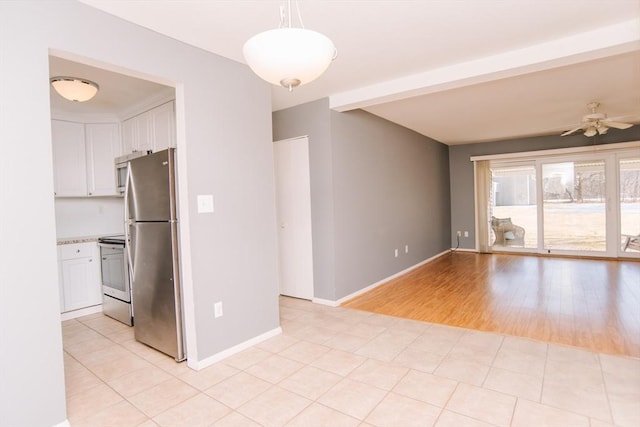 empty room featuring light tile patterned floors, ceiling fan, and baseboards