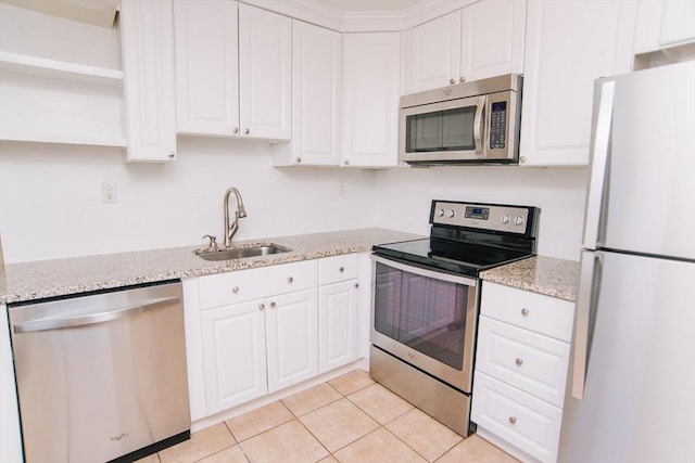 kitchen with light tile patterned floors, white cabinets, stainless steel appliances, open shelves, and a sink