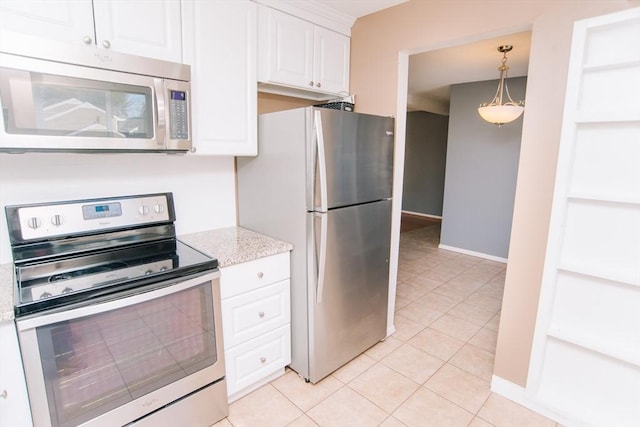 kitchen with light stone counters, appliances with stainless steel finishes, white cabinetry, light tile patterned flooring, and baseboards