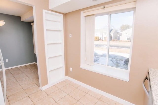 interior space featuring a healthy amount of sunlight, built in features, and light tile patterned flooring