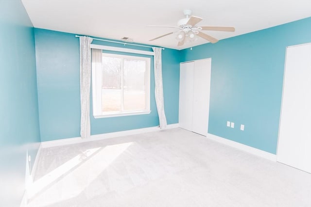 unfurnished room featuring carpet, baseboards, and a ceiling fan