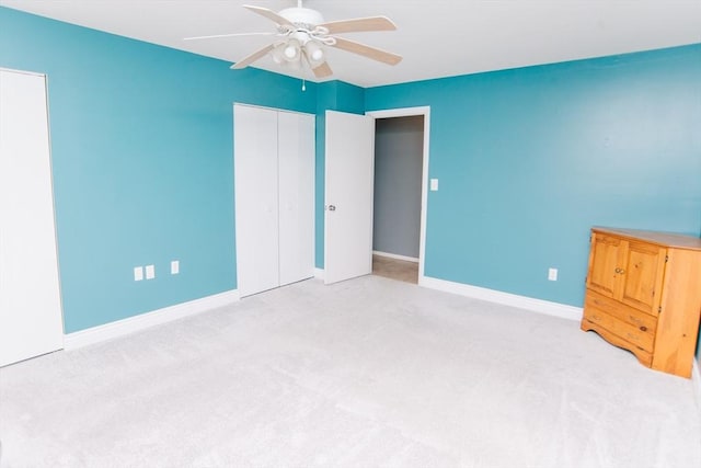 unfurnished bedroom featuring carpet floors, a closet, baseboards, and a ceiling fan