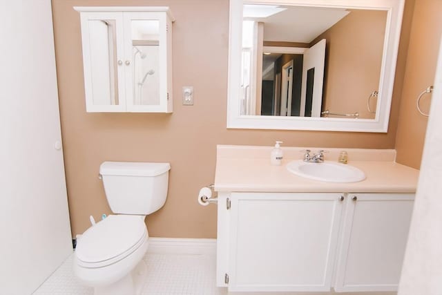 bathroom with tile patterned flooring, baseboards, vanity, and toilet