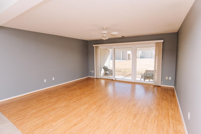 unfurnished room featuring ceiling fan, wood finished floors, and baseboards