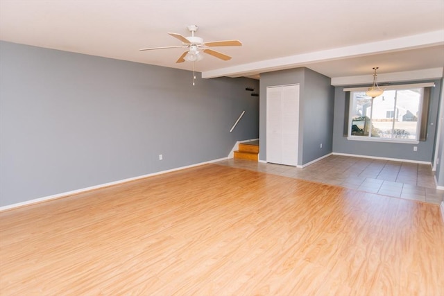 spare room with a ceiling fan, baseboards, and wood finished floors