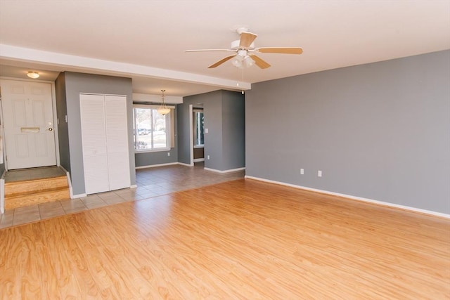 spare room with light wood-style floors, baseboards, and a ceiling fan