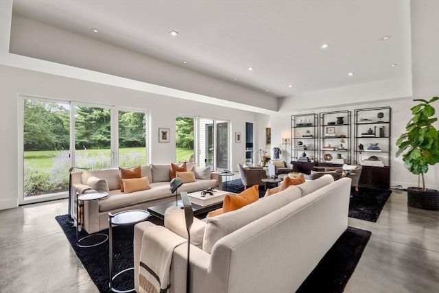 living room featuring recessed lighting, baseboards, and concrete floors