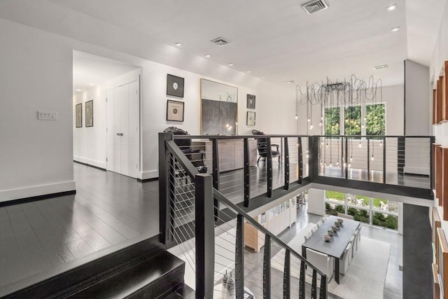 staircase featuring recessed lighting, visible vents, baseboards, and wood finished floors