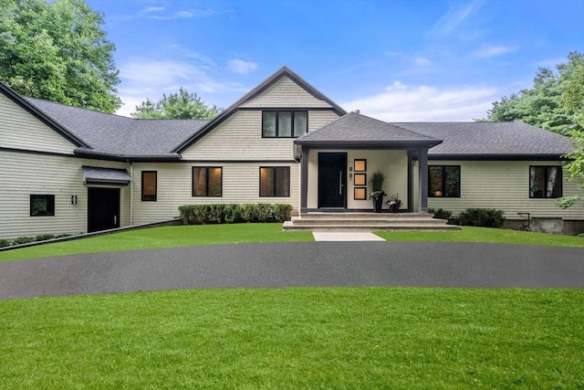 view of front of property featuring a front yard and roof with shingles