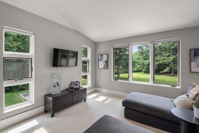 living room featuring light carpet, baseboards, and vaulted ceiling