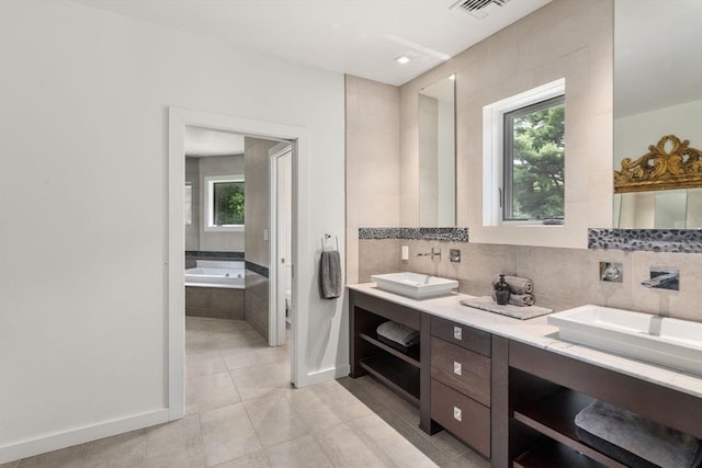 bathroom with visible vents, double vanity, decorative backsplash, tile patterned flooring, and a bath