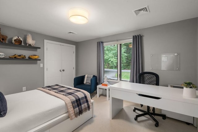 bedroom with light colored carpet, visible vents, and a closet