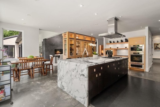 kitchen featuring open shelves, appliances with stainless steel finishes, island range hood, a warming drawer, and a sink