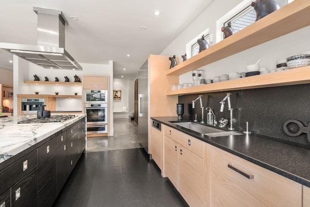 kitchen featuring open shelves, dark cabinets, appliances with stainless steel finishes, island exhaust hood, and a sink